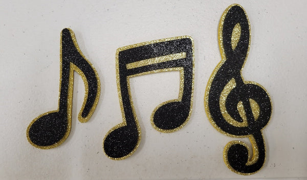 3 símbolos musicales de espuma con purpurina.